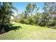 This backyard features an expansive lawn lined with privacy-providing mature trees at 11836 Crawford Parrish Ln, Parrish, FL 34219
