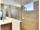 Tiled walk-in shower featuring glass partition, window, and vanity in this modern bathroom at 11836 Crawford Parrish Ln, Parrish, FL 34219