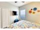 Bedroom with accent flowers and TV with cable hookup, closet, and window with light-blocking shade at 11836 Crawford Parrish Ln, Parrish, FL 34219