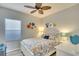 Bright bedroom with decorative ceiling fan, floral bedding, and a window with a shade at 11836 Crawford Parrish Ln, Parrish, FL 34219