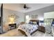 Bedroom features neutral colors, a ceiling fan, a window, and a comfortable chair with side table at 11836 Crawford Parrish Ln, Parrish, FL 34219