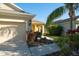 The front exterior of this home shows a two-car garage and a palm tree in the landscaped yard at 11836 Crawford Parrish Ln, Parrish, FL 34219