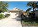 The exterior of this suburban home features a two-car garage and is enhanced by the well-maintained front yard at 11836 Crawford Parrish Ln, Parrish, FL 34219