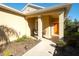 An inviting front porch with chairs awaits at this home with a well-maintained lawn and sidewalk at 11836 Crawford Parrish Ln, Parrish, FL 34219