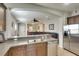 Open-concept kitchen featuring dark cabinetry, stainless steel appliances, and breakfast bar at 11836 Crawford Parrish Ln, Parrish, FL 34219
