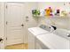 Neat laundry room with modern washer and dryer, storage shelf and tile floor at 11836 Crawford Parrish Ln, Parrish, FL 34219