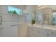 Updated bathroom featuring a glass-enclosed shower, grab bars, and double sinks at 12041 Thornhill Ct, Lakewood Ranch, FL 34202