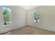 Sunlit bedroom featuring neutral tile flooring, with natural light streaming through two large windows at 12041 Thornhill Ct, Lakewood Ranch, FL 34202