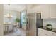 Dining area boasts natural light, view to the kitchen, and stainless steel refrigerator at 12041 Thornhill Ct, Lakewood Ranch, FL 34202