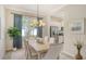 Dining area features a modern chandelier, stylish drapes, and backyard view at 12041 Thornhill Ct, Lakewood Ranch, FL 34202