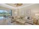 Living room with large sectional sofa, ceiling fan, and pool views at 12041 Thornhill Ct, Lakewood Ranch, FL 34202