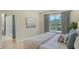 Relaxing main bedroom with waterfront views from a large window, soft decor, and adjacent bath at 12041 Thornhill Ct, Lakewood Ranch, FL 34202