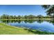 Peaceful lakefront view surrounded by lush greenery and mature trees at 12041 Thornhill Ct, Lakewood Ranch, FL 34202