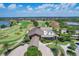 Aerial view of the community golf course, lake, and clubhouse with lush landscaping and sunny skies at 15024 Castle Park Ter, Lakewood Ranch, FL 34202