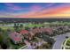 Aerial view of homes and golf course at sunset; colorful skies add beauty at 15024 Castle Park Ter, Lakewood Ranch, FL 34202