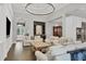 Open-concept living room with hardwood floors, a large chandelier, and a conveniently located wet bar at 15024 Castle Park Ter, Lakewood Ranch, FL 34202