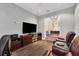 Cozy living room featuring hardwood floors, modern TV, and comfortable seating with a glimpse into the dining area at 15024 Castle Park Ter, Lakewood Ranch, FL 34202