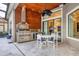 Outdoor kitchen features stainless steel appliances, wooden backsplash, and modern ceiling fan at 15024 Castle Park Ter, Lakewood Ranch, FL 34202