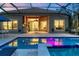 Stunning pool with outdoor kitchen and dining area, illuminated by ambient lighting at 15024 Castle Park Ter, Lakewood Ranch, FL 34202