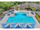 Aerial view of community pool with shade sails, lounge chairs, and meticulously maintained landscaping at 15024 Castle Park Ter, Lakewood Ranch, FL 34202