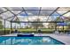 Screened-in pool area featuring pool, jacuzzi, lounge chairs, and lush golf course views at 15024 Castle Park Ter, Lakewood Ranch, FL 34202