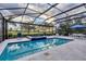 Screened-in pool area with a swimming pool, jacuzzi, blue umbrellas, and golf course view at 15024 Castle Park Ter, Lakewood Ranch, FL 34202