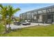 Backyard with a screened in patio with lounge seating and a tropical landscaping at 15104 Blue Bay Ter, Lakewood Ranch, FL 34211