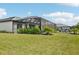 Large backyard featuring a screened-in patio, lush landscaping, and green lawn at 15104 Blue Bay Ter, Lakewood Ranch, FL 34211