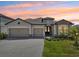 Beautiful exterior elevation with a three-car garage, paver driveway, stone accents and lush landscaping at 15104 Blue Bay Ter, Lakewood Ranch, FL 34211