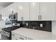 Close up of kitchen backsplash, stainless steel appliances, and white cabinets at 15104 Blue Bay Ter, Lakewood Ranch, FL 34211