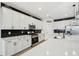Kitchen with white cabinets, stainless steel appliances, and black backsplash at 15104 Blue Bay Ter, Lakewood Ranch, FL 34211