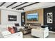 Modern living room featuring a linear fireplace, accent wall, modern ceiling beams, and a large white sectional at 15104 Blue Bay Ter, Lakewood Ranch, FL 34211