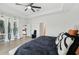 The spacious main bedroom offers lanai access, wood-look flooring, and a modern ceiling fan at 15104 Blue Bay Ter, Lakewood Ranch, FL 34211