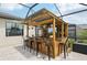 Custom outdoor bar with seating and lighting inside a screened-in patio at 15104 Blue Bay Ter, Lakewood Ranch, FL 34211