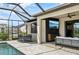 A covered patio features a seating area, TV, and dining table by the pool at 15104 Blue Bay Ter, Lakewood Ranch, FL 34211
