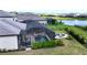 Aerial view of a screened-in pool and patio area complete with dining and lounge furniture overlooking a peaceful lake at 15104 Blue Bay Ter, Lakewood Ranch, FL 34211