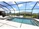 A luxurious screened-in pool area includes a spa, a bar, and a lounge area with relaxing chairs at 15104 Blue Bay Ter, Lakewood Ranch, FL 34211