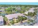An aerial view of a community with townhomes, mature trees, and a serene pond at 1595 Napoli W Dr, Sarasota, FL 34232