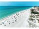Expansive white sandy beach with turquoise water, featuring vacationers enjoying a sunny day near beachfront houses at 1603 Gulf Dr N # 6, Bradenton Beach, FL 34217