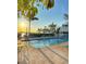 Beautiful community pool with waterfront views at sunset, equipped with lounge seating under shady trees at 1603 Gulf Dr N # 6, Bradenton Beach, FL 34217