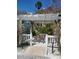 Peaceful outdoor patio featuring stone seating beneath a decorative pergola, surrounded by lush tropical plants and sandy pathways at 1603 Gulf Dr N # 6, Bradenton Beach, FL 34217