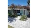 Charming cottage with quaint landscaping, a pergola, and a small seating area, offering a cozy and inviting appeal at 1603 Gulf Dr N # 6, Bradenton Beach, FL 34217