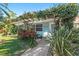 Charming cottage-style home with lush landscaping, pergola, and a welcoming front porch with seating at 1603 Gulf Dr N # 6, Bradenton Beach, FL 34217