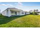 Extensive backyard with lush green grass, white exterior, and covered patio at 16097 Old Fox Trl, Port Charlotte, FL 33953