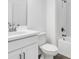 Bathroom featuring a white vanity, white toilet, and tiled tub shower with dark hardware at 16097 Old Fox Trl, Port Charlotte, FL 33953