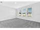 Bright bedroom with neutral carpeting and three windows offering ample natural light at 16097 Old Fox Trl, Port Charlotte, FL 33953