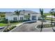 Beautiful clubhouse exterior with attractive landscaping, circular driveway, and charming architectural details at 16097 Old Fox Trl, Port Charlotte, FL 33953