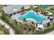 Aerial view of a large community pool with lounge chairs, tables, and landscaping at 16097 Old Fox Trl, Port Charlotte, FL 33953
