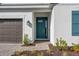 Inviting home entrance with a teal front door, stone walkway, and modern exterior lighting at 16097 Old Fox Trl, Port Charlotte, FL 33953