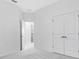 Hallway featuring white walls, gray carpet and access to an adjacent room with a laundry machine visible at 16097 Old Fox Trl, Port Charlotte, FL 33953